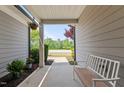 Covered porch with bench and decor invites relaxation and provides neighborhood views at 1112 Monterey Bay Dr, Wake Forest, NC 27587