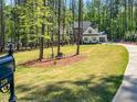 Expansive front yard of home featuring mature trees, a bicycle, and a long paved driveway at 1218 Rogers Farm Rd, Wake Forest, NC 27587