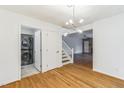 Open dining area with hardwood floors, modern light fixture, adjacent washer and dryer, and stairs at 127 Finley Forest Dr, Chapel Hill, NC 27517