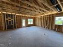 Unfinished living room boasts a spacious layout with exposed framing, awaiting your personal touch for customization at 136 Tuskeegee Dr, Smithfield, NC 27577