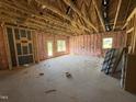 Large living room under construction with exposed beams and natural light at 136 Tuskeegee Dr, Smithfield, NC 27577