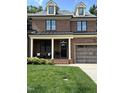 Charming brick townhouse featuring a two-car garage and welcoming front porch seating at 137 Cofield Cir, Durham, NC 27707