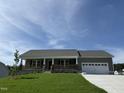 Charming single-story home features a welcoming front porch and attached two-car garage at 152 Tulipfield Way, Benson, NC 27504