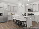 Modern kitchen with gray cabinetry, quartz countertops, island with bar seating, and stainless appliances at 157 N District Ave # 291, Clayton, NC 27527