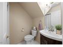 Bright bathroom featuring vanity with dark wood cabinets, toilet, and towel rack at 1602 Township Cir, Raleigh, NC 27609