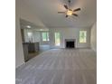 Open-concept living area with a fireplace, ceiling fan, and seamless flow into the kitchen and outdoor deck at 171 Tulipfield Way, Benson, NC 27504