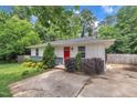 Charming single-story home with vibrant landscaping, a driveway, and a bright red front door at 1717 Martin Luther King Jr Blvd, Raleigh, NC 27610