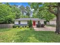 Charming single-story home featuring a well-manicured lawn and a vibrant red front door at 1717 Martin Luther King Jr Blvd, Raleigh, NC 27610