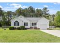Well-manicured front lawn with white home, featuring a garage and quaint, inviting front porch at 1752 Cobblestone Dr, Creedmoor, NC 27522