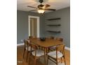 Dining room showcasing a wooden table, chairs, and floating wooden shelves on gray walls at 200 S Pettigrew St, Raleigh, NC 27610