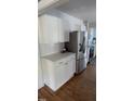 Modern kitchen featuring sleek stainless steel appliances, white cabinetry, and hardwood floors at 200 S Pettigrew St, Raleigh, NC 27610