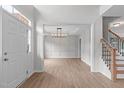 Spacious foyer with light hardwood floors, a view of dining room, and open staircase at 2003 Red Sage Ct, Apex, NC 27502