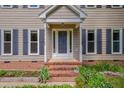 Inviting front porch with brick steps, surrounded by lush greenery and charming flower beds at 203 N Becket St, Cary, NC 27513