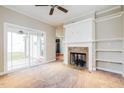 Open living space with fireplace, ceiling fan, and access to outdoor area at 234 Lars Ln, Garner, NC 27529