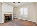 Cozy living room with neutral carpet, fireplace, and built-in shelving at 234 Lars Ln, Garner, NC 27529
