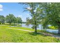 Beautiful backyard with large mature trees, lush green grass, and relaxing lake views at 2404 Azalea Dr, Durham, NC 27703