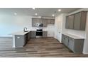Modern kitchen features stainless steel appliances, white quartz countertops, and grey cabinets at 2411 Whitewing Ln, Wendell, NC 27591