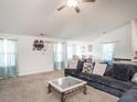 Spacious living room with neutral carpet, a large couch, and ample natural light at 304 Anaconda Trl, Mebane, NC 27302