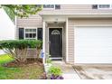 Close up view of front door with manicured shrubs and two-car garage at 313 Weeping Willow Dr, Durham, NC 27704