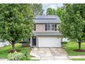 Two-story home with a two-car garage, well-manicured lawn, and mature trees at 313 Weeping Willow Dr, Durham, NC 27704