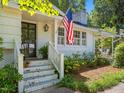 Welcoming front entrance with a black front door, brick stairs and an American flag at 4112 Rowan St, Raleigh, NC 27609