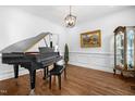 Classic living room with a grand piano, hardwood floors, and elegant decor at 4412 Thistlehill Ct, Raleigh, NC 27616