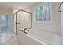 Modern bathroom featuring a soaking tub, glass-enclosed shower, and marble tile flooring at 5491 Silk Hope Gum Springs Rd, Siler City, NC 27344