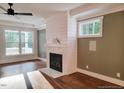 Cozy living room featuring a fireplace with herringbone tile and hardwood floors at 5491 Silk Hope Gum Springs Rd, Siler City, NC 27344