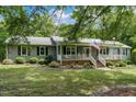 Single-story home with a welcoming front porch, landscaped yard and American Flag at 578 Jeffries Cross Rd, Burlington, NC 27217
