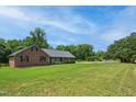 Single-story brick home boasting a lush green lawn and mature trees at 8509 Ashwood Dr, Raleigh, NC 27603