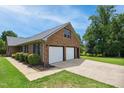 Two-car garage with fresh white doors and charming landscaped surroundings at 8509 Ashwood Dr, Raleigh, NC 27603