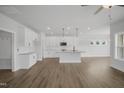 Bright open kitchen featuring white cabinetry, an island with pendant lighting, stainless steel appliances, and hardwood flooring at 91 Merle Way Way, Wendell, NC 27591