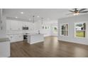 Bright open kitchen featuring white cabinetry, an island with pendant lighting, stainless steel appliances, and hardwood flooring at 91 Merle Way Way, Wendell, NC 27591