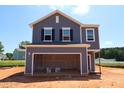Charming new construction home with a covered garage and blue siding against a bright blue sky at 970 Bombardier Aly, Spring Hope, NC 27882