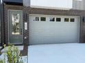 Attached one car garage with gray door and glass paneled entry door at 1002 Regalia Rd # 2, Durham, NC 27713