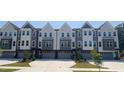 Row of modern townhomes feature neutral exteriors, garages, and professional landscaping at 1004 Regalia Rd # 3, Durham, NC 27713