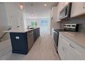 Modern kitchen with white cabinets, stainless steel appliances, and a center island with sink at 1006 Regalia Rd # 4, Durham, NC 27713