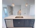 Kitchen island with stainless steel sink, dishwasher, navy cabinets and pendant lights at 1006 Regalia Rd # 4, Durham, NC 27713