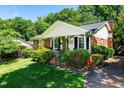 Charming home with lush lawn, brick exterior, mature trees, and inviting front porch at 1008 Mockingbird Dr, Raleigh, NC 27615