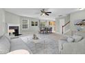 Bright living room with fireplace, ceiling fan, and dining area, creating a warm and inviting atmosphere at 105 Walehurst Ridge Dr, Angier, NC 27501