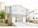 Modern duplex with two-story design, gray siding, and white garage doors, offering appealing curb appeal at 107 S Plum St, Durham, NC 27703