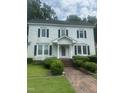 Inviting two-story home with classic architectural details and a brick pathway leading to the entrance at 112 E Sycamore St, Zebulon, NC 27597
