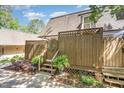 Exterior view of property showing a private wooden fence, staircase, and nicely planted landscaping at 119 Brookberry Cir, Chapel Hill, NC 27517