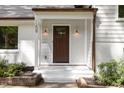Close-up of a beautiful front porch and a wood front door with sidelights and elegant outdoor lighting fixtures at 1209 Lanark Ct, Cary, NC 27511