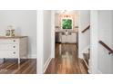 Hallway leading to the kitchen and stairs, featuring beautiful wood floors and fresh paint and plenty of natural light at 1209 Lanark Ct, Cary, NC 27511