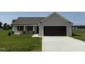 Charming single-story home with neutral siding, attached garage, and well-manicured lawn at 128 Coharie Dr, Lillington, NC 27546