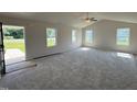 Bright living room featuring carpet floors, vaulted ceiling with fan, and multiple windows offering ample natural light at 128 Coharie Dr, Lillington, NC 27546