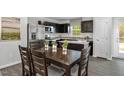 Inviting dining area adjacent to the kitchen features a stylish table set and view of stainless appliances at 1537 Ivy Meadow Ln, Zebulon, NC 27597