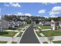 Picturesque street view of single Gathering homes lining the road with green lawns at 1537 Ivy Meadow Ln, Zebulon, NC 27597