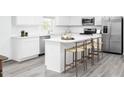 Bright kitchen featuring white cabinets, quartz countertops, stainless steel appliances, and a breakfast bar with seating at 1541 Ivy Meadow Ln, Zebulon, NC 27597